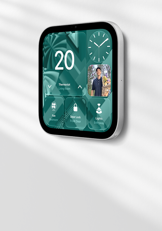 Apple HomeView wall-mounted model on a wall, silver color, displaying time, temperature, and controls for thermostat, bedroom fan, door lock, and lights
