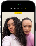 iPhone 18 Pro, black, front exterior, displaying two models posing for the camera, demonstrating the Center Stage front camera
